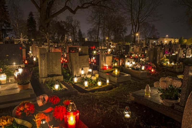 Lit candles in a cemetery commemorating All Saints' Day